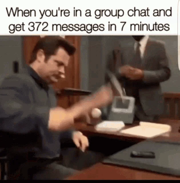 A GIF of a man in an office angrily hitting a phone with a shoe, with a caption about getting too many messages in a group chat